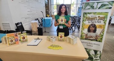 Mercy University employee Adriana Erin Rivera poses with her book Paloma’s Song for Puerto Rico: A Diary from 1898 