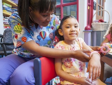 Nurse wrapping bandage on the wrist of a child